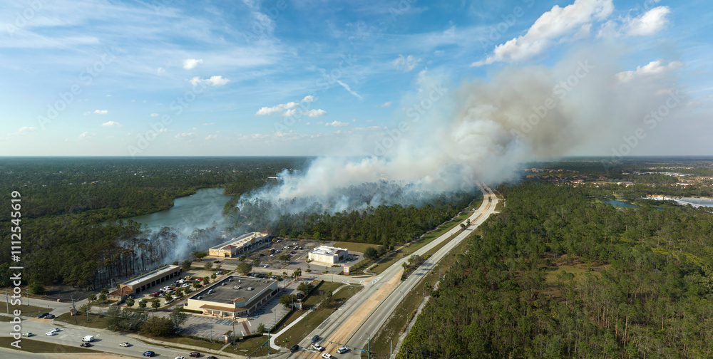 Aerial view of strong wildfire burning severely in North Port city, Florida. Natural disaster during dry season in jungle woods