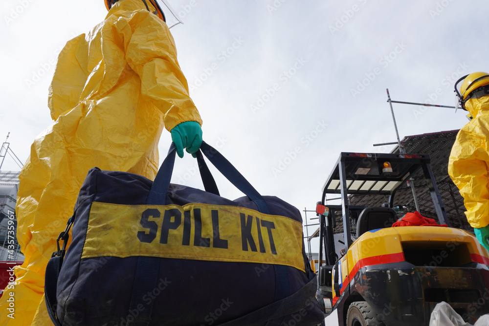 Rescue personnel wear yellow chemical protective clothing during chemical spill recover as part of emergency drills at chemical plant.